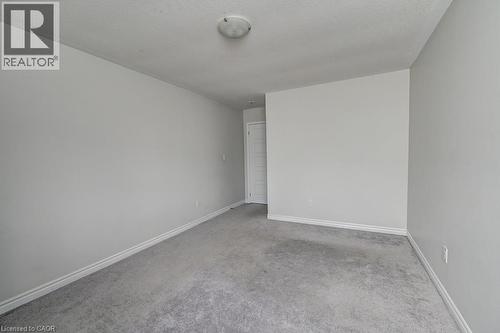 Light-toned wall finishes, neutral carpet, and white trim molding create a versatile interior - 236 Ridge Road, Cambridge, ON 