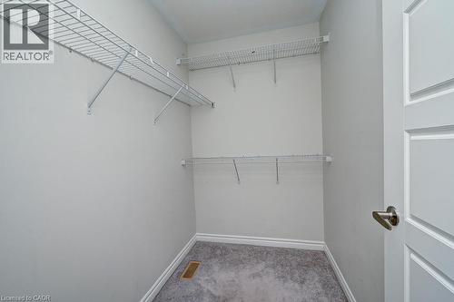 White wire shelving system, light gray wall paint, gray carpeting, white trim, and a paneled interior door with brushed nickel hardware - 236 Ridge Road, Cambridge, ON 