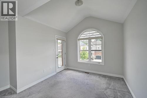 Vaulted ceiling, arched window with horizontal blinds, glass panel door, gray carpeting, and white trim - 236 Ridge Road, Cambridge, ON 