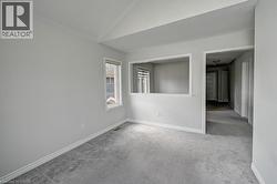 Neutral wall finishes with white trim, vaulted ceiling, and carpeted flooring - 