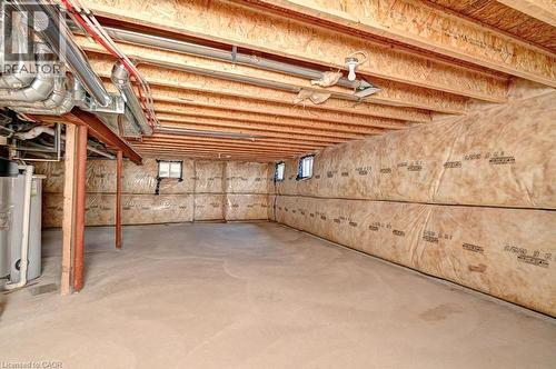 Spacious unfinished basement featuring exposed wood joists, insulated walls, concrete flooring, and multiple small windows - 236 Ridge Road, Cambridge, ON 