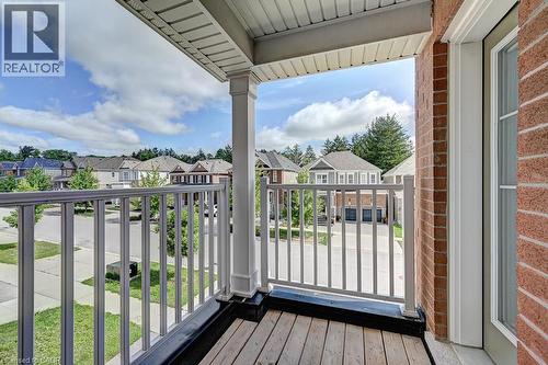 Balcony with wood-finish flooring, white railing, and brick wall - 236 Ridge Road, Cambridge, ON 