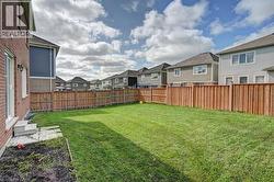 Expansive fenced backyard featuring a manicured lawn - 