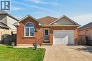 Brick exterior with an integrated single-car garage, concrete driveway, and an arched window - 795 Tenth Avenue, Hamilton, ON 