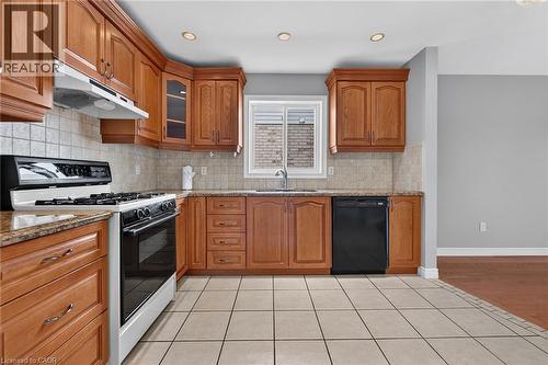 Kitchen featuring wood cabinetry, light-toned tile flooring, recessed lighting, and a window above the sink - 795 Tenth Avenue, Hamilton, ON 