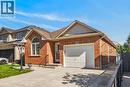 AI generated staging Brick exterior with an arched window, attached garage, concrete driveway, and wrought iron gate - 795 Tenth Avenue, Hamilton, ON 