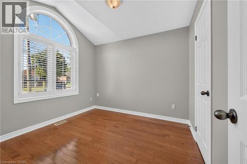 Wood-finish flooring, vaulted ceiling, arched window with plantation shutters, paneled door, and recessed lighting - 795 Tenth Avenue, Hamilton, ON 