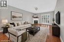 Wood-finish flooring, light gray wall paint, white fireplace with mantle, and white multi-pane glass doors - 795 Tenth Avenue, Hamilton, ON 