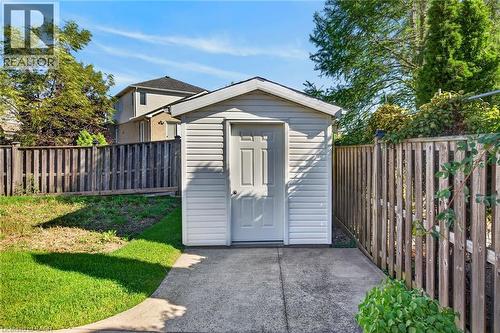 Detached storage shed with siding exterior, paneled door, and concrete pad - 795 Tenth Avenue, Hamilton, ON 