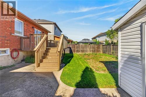 Red brick exterior with a wooden deck and stairs - 795 Tenth Avenue, Hamilton, ON 