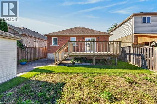 Brick exterior with a wood deck, sliding glass doors, white trim windows, and a detached shed - 795 Tenth Avenue, Hamilton, ON 