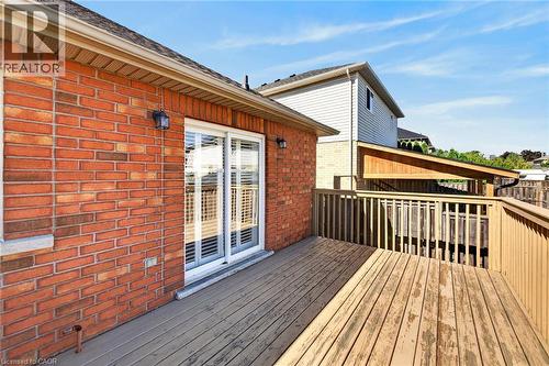 Expansive wood-finish deck with railing, brick exterior, and sliding glass door - 795 Tenth Avenue, Hamilton, ON 