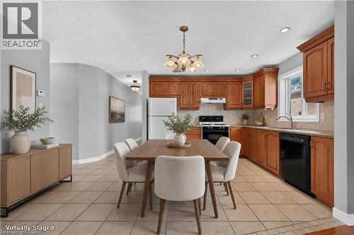 AI generated staging. Kitchen featuring wood cabinetry, light-toned tile flooring, recessed lighting, and a window above the sink - 795 Tenth Avenue, Hamilton, ON 