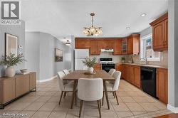 AI generated staging. Kitchen featuring wood cabinetry, light-toned tile flooring, recessed lighting, and a window above the sink - 
