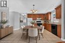 AI generated staging. Kitchen featuring wood cabinetry, light-toned tile flooring, recessed lighting, and a window above the sink - 795 Tenth Avenue, Hamilton, ON 