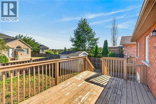 Expansive wooden deck with railing, brick exterior, and outdoor lighting fixture - 795 Tenth Avenue, Hamilton, ON 