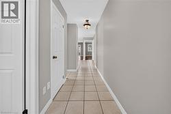 Tile flooring throughout, neutral wall tones, white interior doors, and overhead lighting fixtures - 