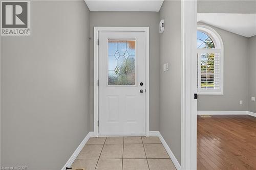 Entryway featuring tile flooring, a white paneled door with decorative glass, and light gray walls - 795 Tenth Avenue, Hamilton, ON 
