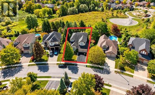 Two-story residence featuring a gray shingle roof, attached garage, and a paved driveway - 74 Davidson Boulevard, Dundas, ON 