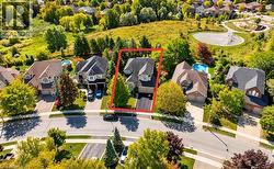 Two-story residence featuring a gray shingle roof, attached garage, and a paved driveway - 