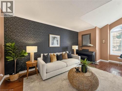 Hardwood-finish flooring, accent wall with patterned wallpaper, crown molding, and an arched window - 74 Davidson Boulevard, Dundas, ON 