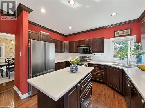 Kitchen featuring rich wood cabinetry, stainless steel appliances, a center island with a light-toned countertop, and recessed lighting - 74 Davidson Boulevard, Dundas, ON 