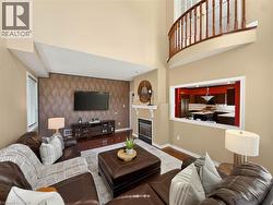 Two-story living area with a built-in fireplace, wood-finish flooring, and an interior balcony - 