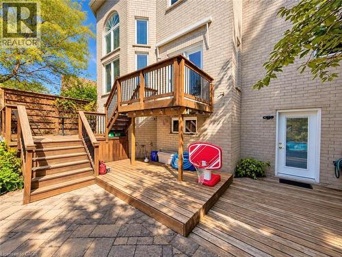 Tiered wood deck with multiple access points, integrated wood privacy fencing, and a lower patio area featuring stone pavers - 74 Davidson Boulevard, Dundas, ON 