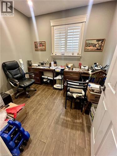 Wood-finish flooring, recessed lighting, and a window with plantation shutters - 5 Arden Avenue, Hamilton, ON 