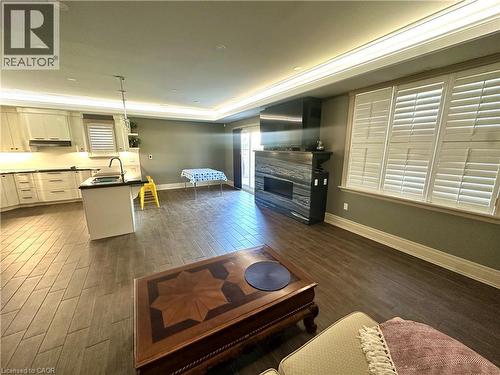 Wood-finish flooring, recessed lighting, crown molding, kitchen island with sink, and custom window shutters - 5 Arden Avenue, Hamilton, ON 