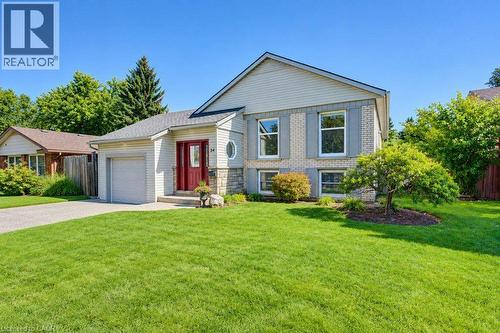 Split-level residence featuring a brick and siding exterior, an attached garage,  and a paved driveway - 34 Wayne Drive, Kitchener, ON 