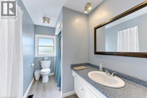 Vanity with integrated sink, wood-finish flooring, framed mirror, and track lighting - 34 Wayne Drive, Kitchener, ON 