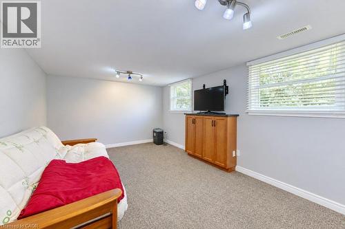 Recessed lighting, wood-finish cabinetry with dark countertop, multiple windows with blinds, and carpeted flooring - 34 Wayne Drive, Kitchener, ON 