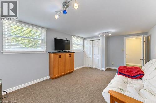 Recessed windows with blinds, built-in wood-finish cabinetry, neutral carpeting, and track lighting - 34 Wayne Drive, Kitchener, ON 