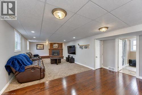 Wood-finish flooring, recessed lighting, and a brick gas fireplace - 34 Wayne Drive, Kitchener, ON 