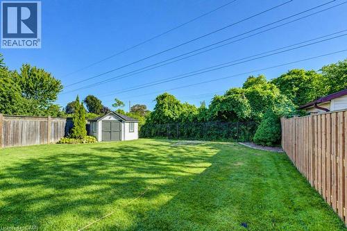 Expansive backyard featuring a manicured lawn, a detached storage shed, privacy fencing, and mature perimeter trees - 34 Wayne Drive, Kitchener, ON 