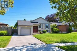 Brick and siding exterior with a dark shingle roof, an attached garage and double drive - 