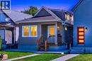 Curb appeal featuring a covered front porch, an exterior light fixture, and a wooden staircase with black railings - 4 Albemarle Street, Hamilton, ON 