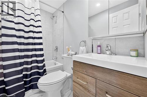 Integrated sink with single-handle faucet, wood-finish vanity, and tiled backsplash - 4 Albemarle Street, Hamilton, ON 