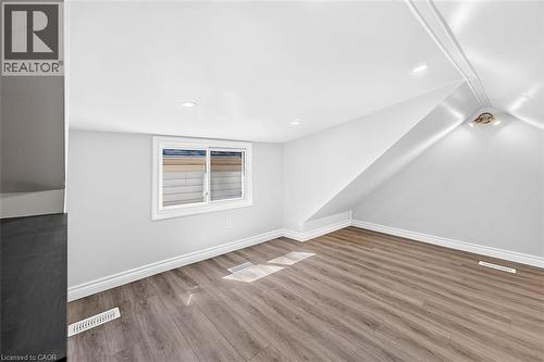 Wood-finish flooring, white walls, recessed lighting, white trim, and a window with white casing - 4 Albemarle Street, Hamilton, ON 