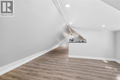 Sloped ceiling with recessed lighting, wood-finish flooring, white walls, and built-in counter space - 4 Albemarle Street, Hamilton, ON 