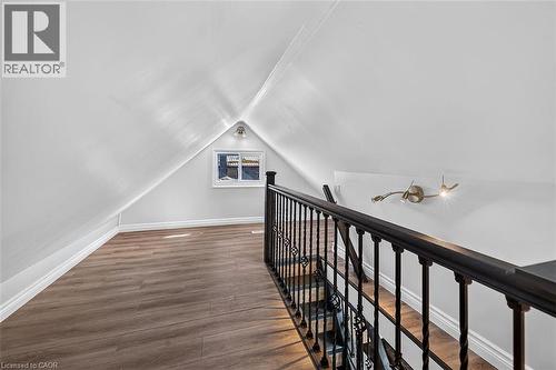 Attic space featuring wood-finish flooring, a window, and a built-in wall sconce - 4 Albemarle Street, Hamilton, ON 