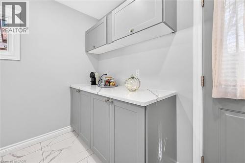 Built-in cabinetry with light gray finish, white countertop, and tile flooring with a marble-effect pattern - 4 Albemarle Street, Hamilton, ON 