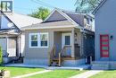 Siding exterior with white trim, covered front porch, and wood stairs with black railings - 4 Albemarle Street, Hamilton, ON 