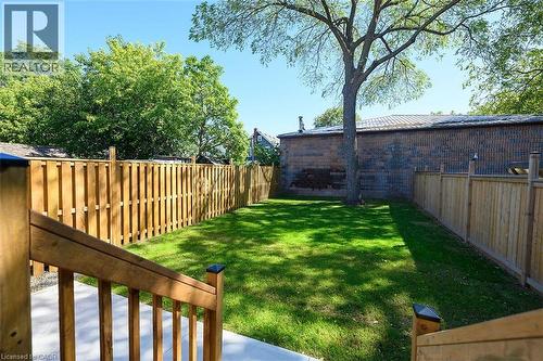 Expansive lawn area with a perimeter wood fence and mature tree - 4 Albemarle Street, Hamilton, ON 
