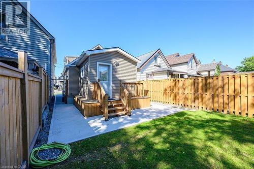 Expansive backyard featuring a manicured lawn, a concrete walkway, a wooden privacy fence, and a raised wooden deck with stairs - 4 Albemarle Street, Hamilton, ON 