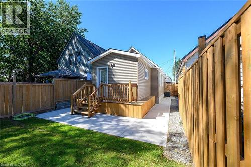 Rear exterior with siding, wood deck, concrete patio, and a side yard with gravel - 4 Albemarle Street, Hamilton, ON 