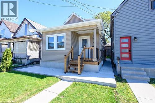 Front facade with horizontal siding, covered porch, and exterior lighting - 4 Albemarle Street, Hamilton, ON 