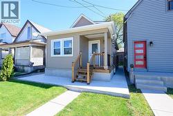 Front facade with horizontal siding, covered porch, and exterior lighting - 