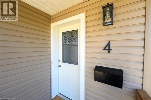 Entry door with decorative glass insert, metal wall-mounted mailbox, and exterior wall lantern - 4 Albemarle Street, Hamilton, ON 